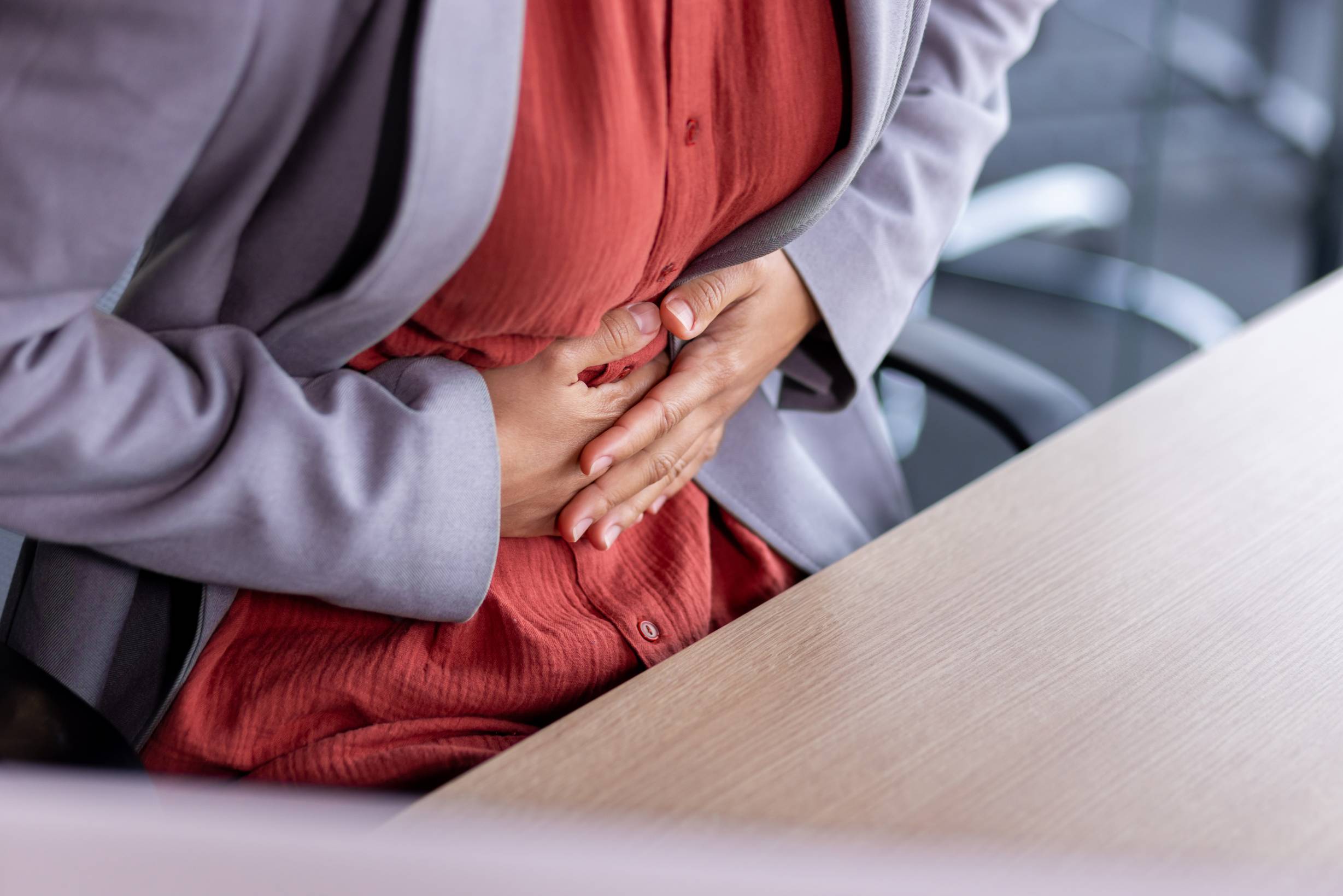 stomach ache sick business woman holding hands on 2026 03 24 16 31 24 utc 1