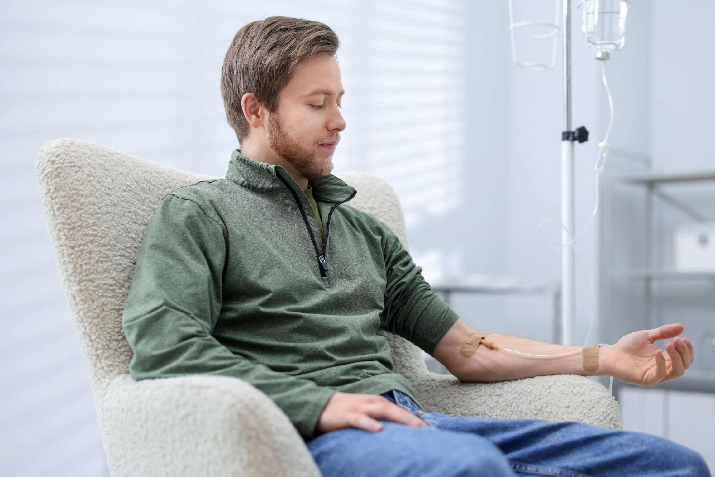 young man with iv drip in armchair at hospital 2026 05 25 20 13 31 utc 1