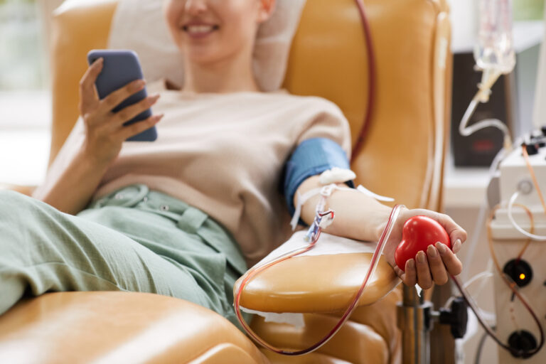 woman donating blood while using mobile phone 2026 03 18 15 41 51 utc